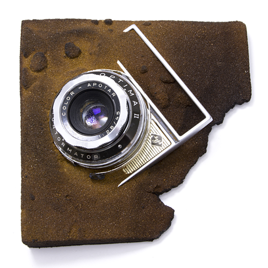 Hommage à Robert Capa, 2015, camera, sand, &c., mixed media, 140 x 140 mm